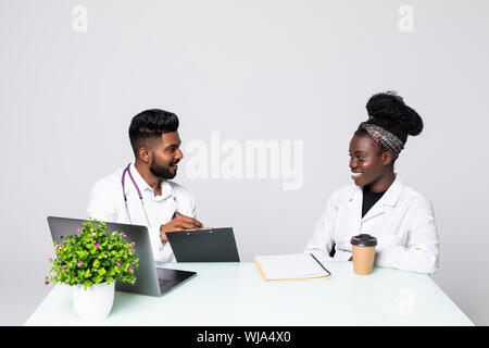 Photo of two doctors together discussing new way of treatment while having a meeting at office. Stock Photo