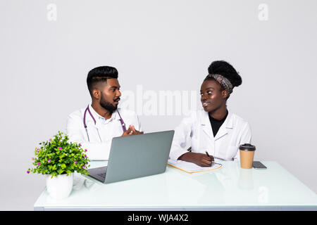 Photo of two doctors together discussing new way of treatment while having a meeting at office. Stock Photo