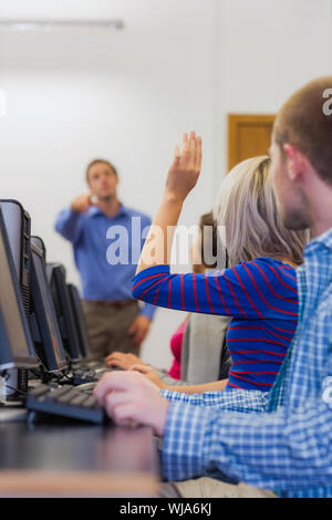 Teacher explaining to young college students in the computer room Stock Photo