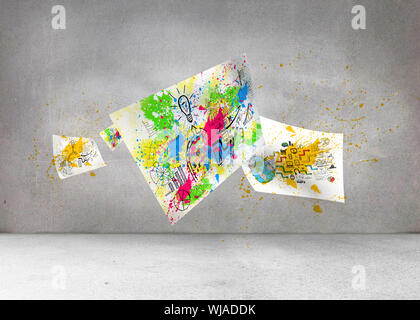 Sheets with graphics and splashes over grey wall Stock Photo