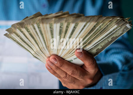 Indian business man holding piles of indian 500 rupee currency for paying bills and payments. School, college, grocery, monthly expenses and other pay Stock Photo
