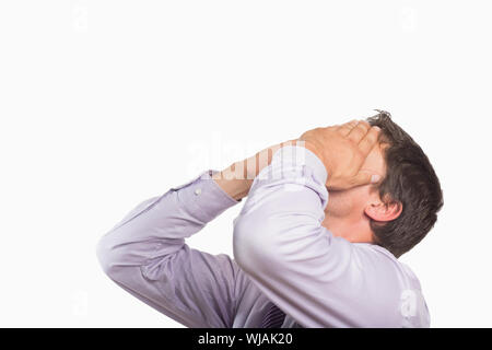 Worried businessman with hands covering face Stock Photo