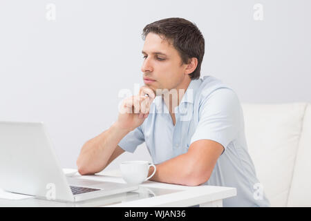 Side view of a serious man using laptop at home Stock Photo