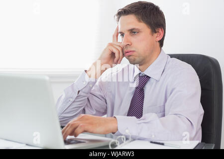 Worried businessman using laptop in office Stock Photo
