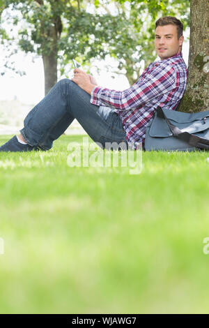 Happy student using his tablet to study outside Stock Photo