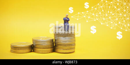 Business concept. Businessman sitting on a pile of silver coins. Stock Photo