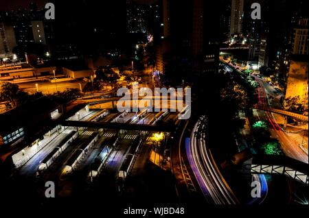 Aerial shot of cars driving on the road near city buildings in Sao Paulo at night time Stock Photo