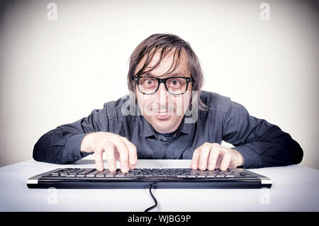 Hacker typing on the keyboard and mocking Stock Photo