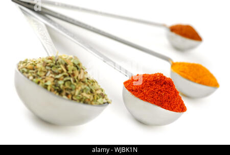 Assorted spices in metal measuring spoons on white background Stock Photo