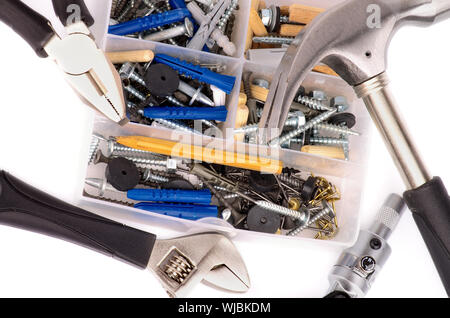 Arrangement of Work Tools and Box with Various Fasteners closeup on white background Stock Photo