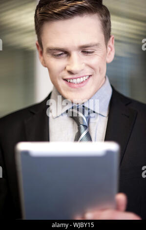Corporate guy using tablet pc at workplace Stock Photo