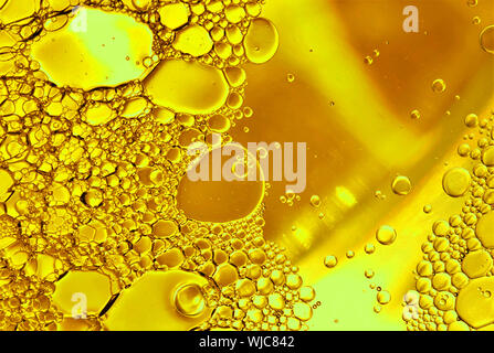 Oil and water bubbles close up in yellow. Stock Photo