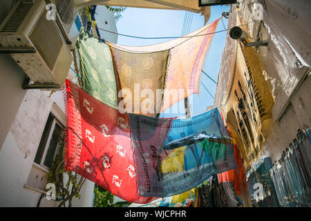 colored foulards hanging between houses in back lit. Stock Photo