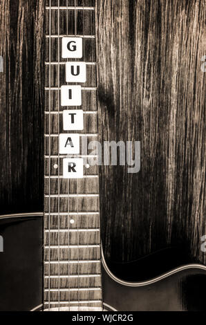 Acoustic guitar in vintage style on wood texture background Stock Photo