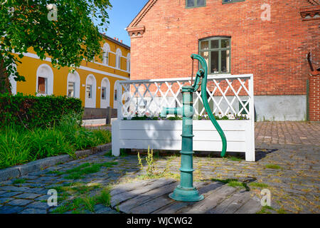 Turquoise fire hydrant on a street with colorful buildings on a summer day Stock Photo