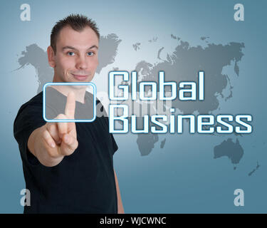 Young man press digital Global Business button on interface in front of him Stock Photo