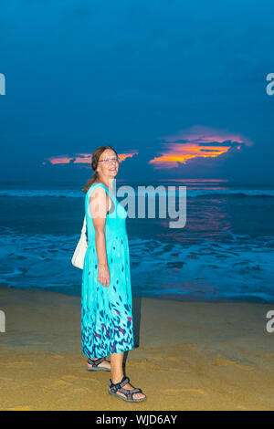 Woman against sunset over a beach in Wadduwa in the Western Province of Sri Lanka, Asia Stock Photo