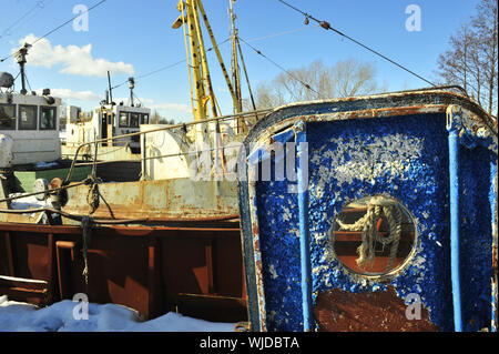 Blue, rusty door of the aged ship with a window. Navigation is closed - Winter Stock Photo