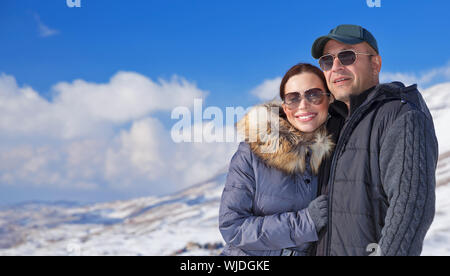 Happy travelers in snowy mountains Stock Photo