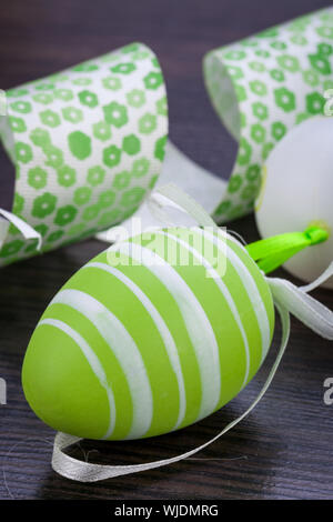 Collection of four hand decorated colourful green Easter eggs with different patterns displayed in straw, close up view Stock Photo