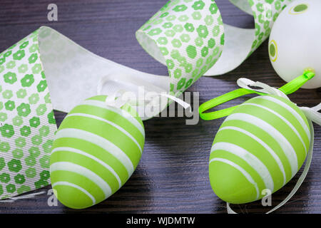 Collection of four hand decorated colourful green Easter eggs with different patterns displayed in straw, close up view Stock Photo