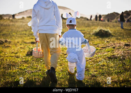 Two brothers in Easter costumes on an Easter egg hunt Stock Photo