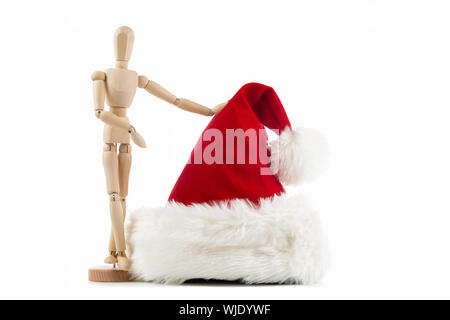 wooden toy figure with a Santa Claus red hat on white background Stock Photo