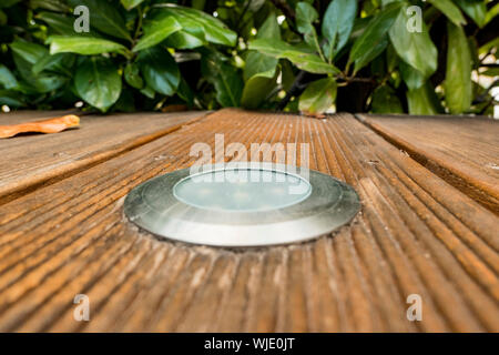 Installation of LED spotlights in a wooden terrace in the garden Stock Photo