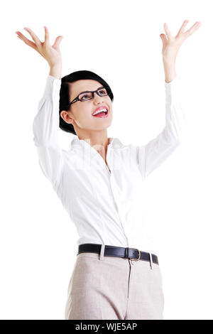 Smiling young woman is holding something abstract above her head. Happy girl with raised hands. Isolated on white background. Stock Photo