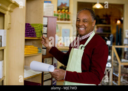 Sales clerk smiling at the camera and pointing to candles Stock Photo