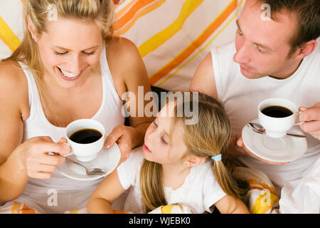 Family breakfasting in bed Stock Photo