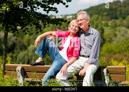 Senior couple sitting on bench Stock Photo