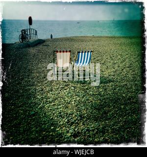 Two Deck Chairs On Beach