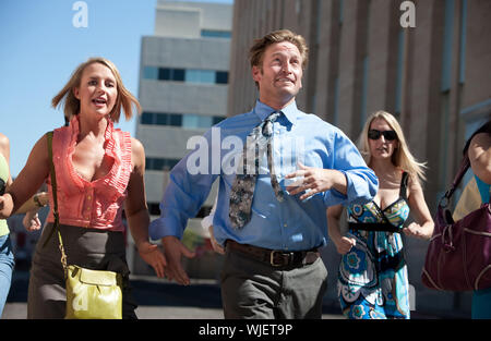 Man races ahead of women in the city. Stock Photo
