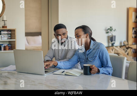Young African American couple sitting at home doing online banking Stock Photo