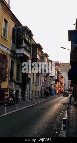 Vertical shot of a car on a narrow road with houses with balconies Stock Photo