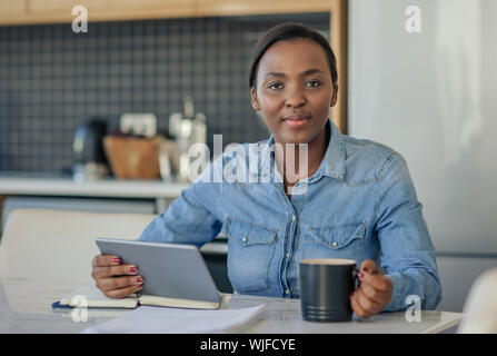 Smiling African American woman using a digital tablet at home Stock Photo