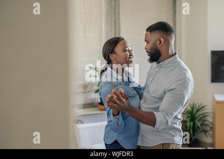 Smiling young African American couple dancing together at home Stock Photo