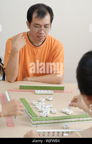 Chinese man play Mahjong, traditional China gamble. Stock Photo