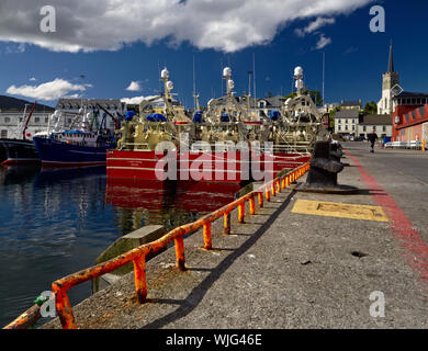 Killybegs, Co. Donegal, Ireland - May 21st, 2019 - Three identical red fishing vessels moored side by side at the pier in Killybegs Harbour (rear view Stock Photo