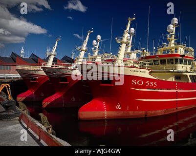 Killybegs, Co. Donegal, Ireland - May 21st, 2019 - Three identical red fishing vessels moored side by side at the pier in Killybegs Harbour Stock Photo