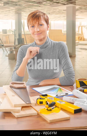 female worker sitting at table with tools Stock Photo
