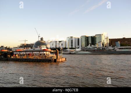 London/UK - August 31, 2014: Panoramic view to the embankment on the  Thames river, the cityscape and HMS Belfast at sunset. Stock Photo