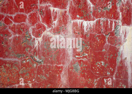 Red dirty cracked concrete wall background with stains Stock Photo