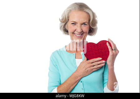 Pretty woman holding heart shaped gift box Stock Photo