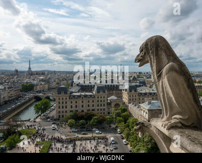 A gargoyle looks out over the city of Paris from the heights of Notre Dame Cathedral before the fire of 2019 Stock Photo