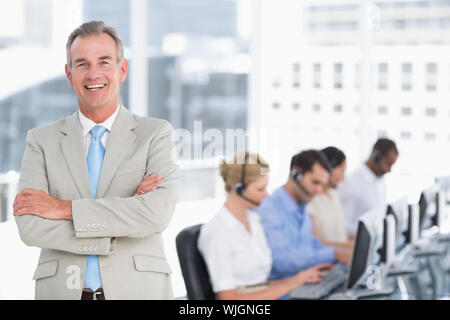 Portrait of a happy businessman with executives using computers in the office Stock Photo