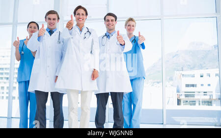 Group portrait of young doctors gesturing thumbs up at hospital Stock Photo