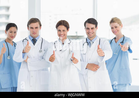 Group portrait of young doctors gesturing thumbs up at hospital Stock Photo