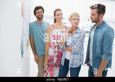 Group of artists in discussion in front of whiteboard at office Stock Photo